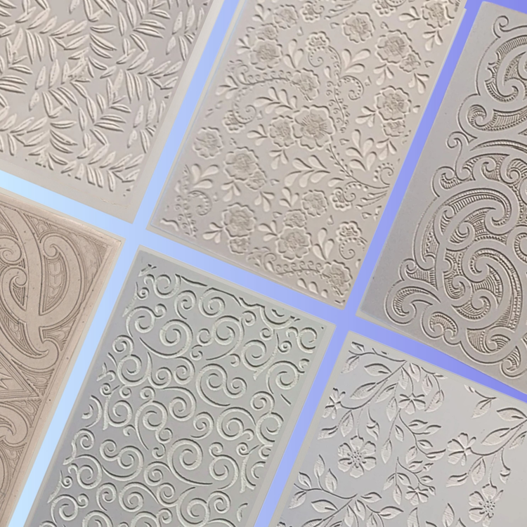 Six embossed rectangular stencil sheets featuring intricate floral and swirl patterns are displayed on a soft blue gradient background, arranged in a neat and slanted grid for a clean, organized presentation.