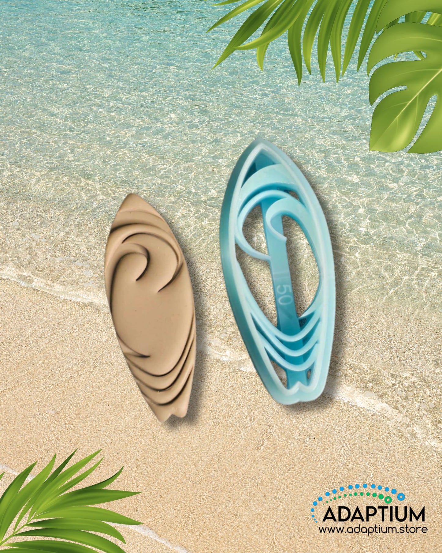 Blue surfboard polymer clay cutter with matching tan clay piece featuring swirl details, placed on sandy beach with clear ocean water and tropical leaves.