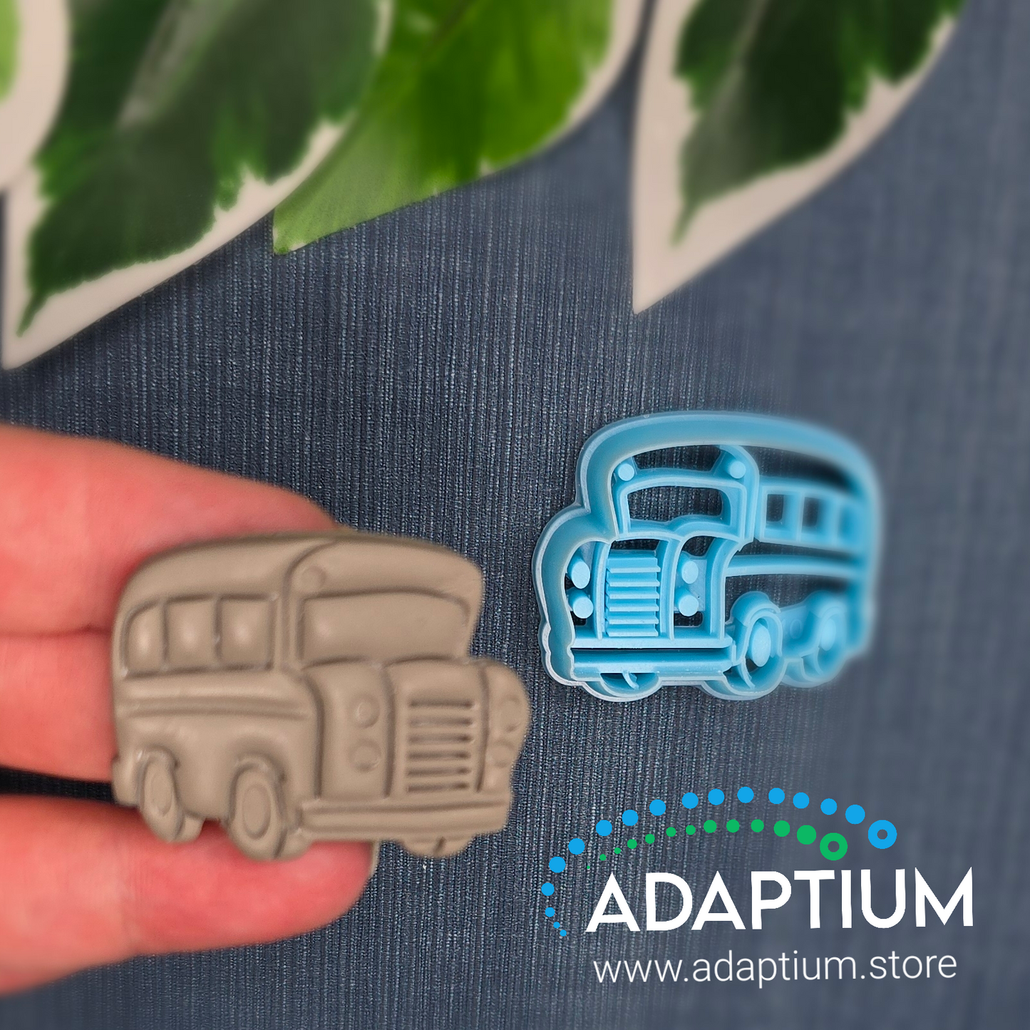 Hand holding a sharp, sky blue American School Bus style resin cutter for polymer Clay