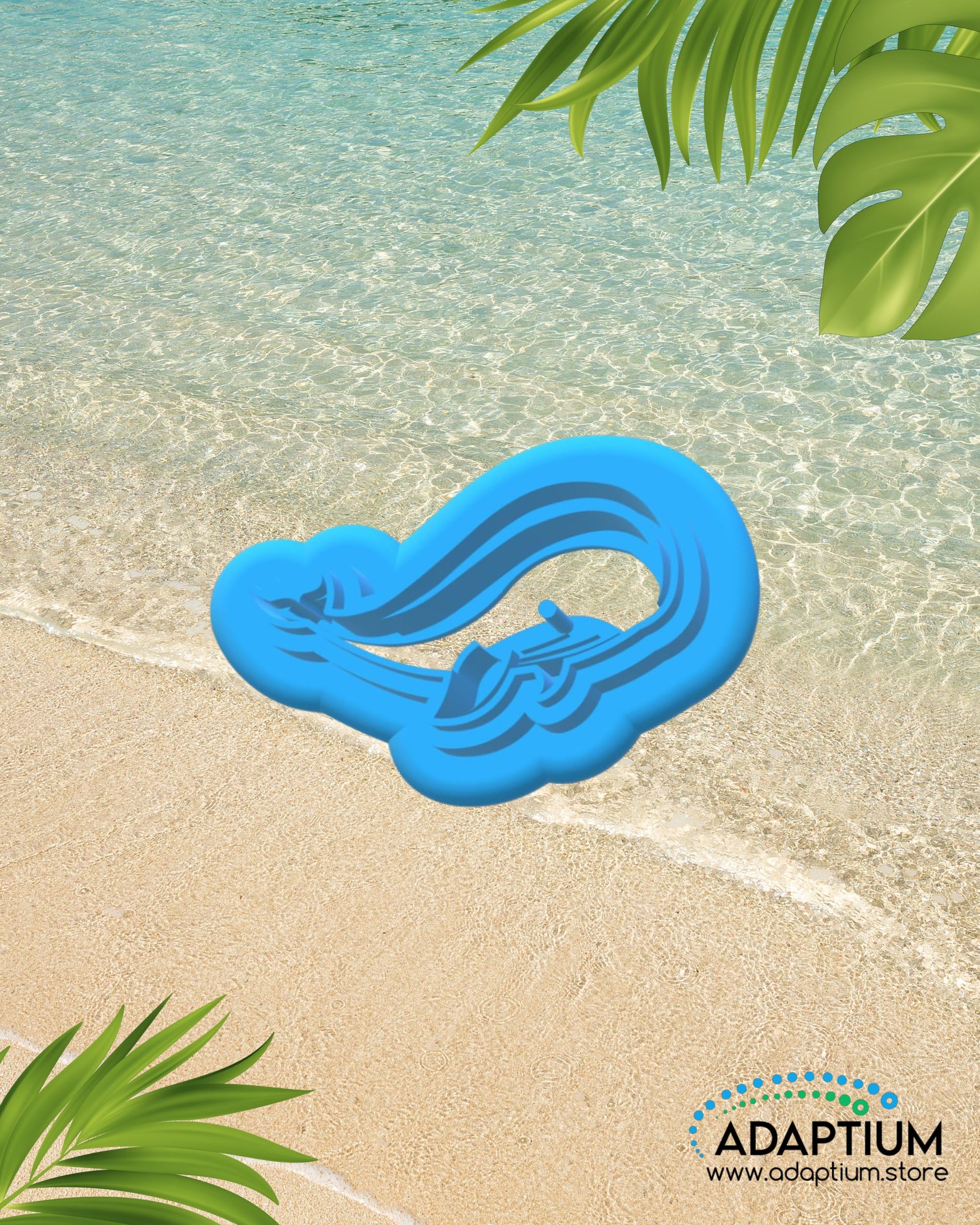 Whale shaped polymer clay cutter placed on sandy beach background with ocean water and tropical leaves.