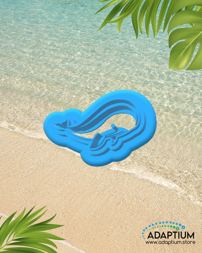Whale shaped polymer clay cutter placed on sandy beach background with ocean water and tropical leaves.