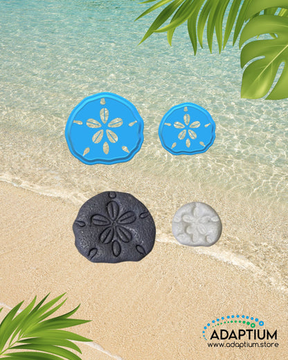 Sand dollar shaped polymer clay cutter with clay sample placed on sandy beach background with ocean water and tropical leaves.
