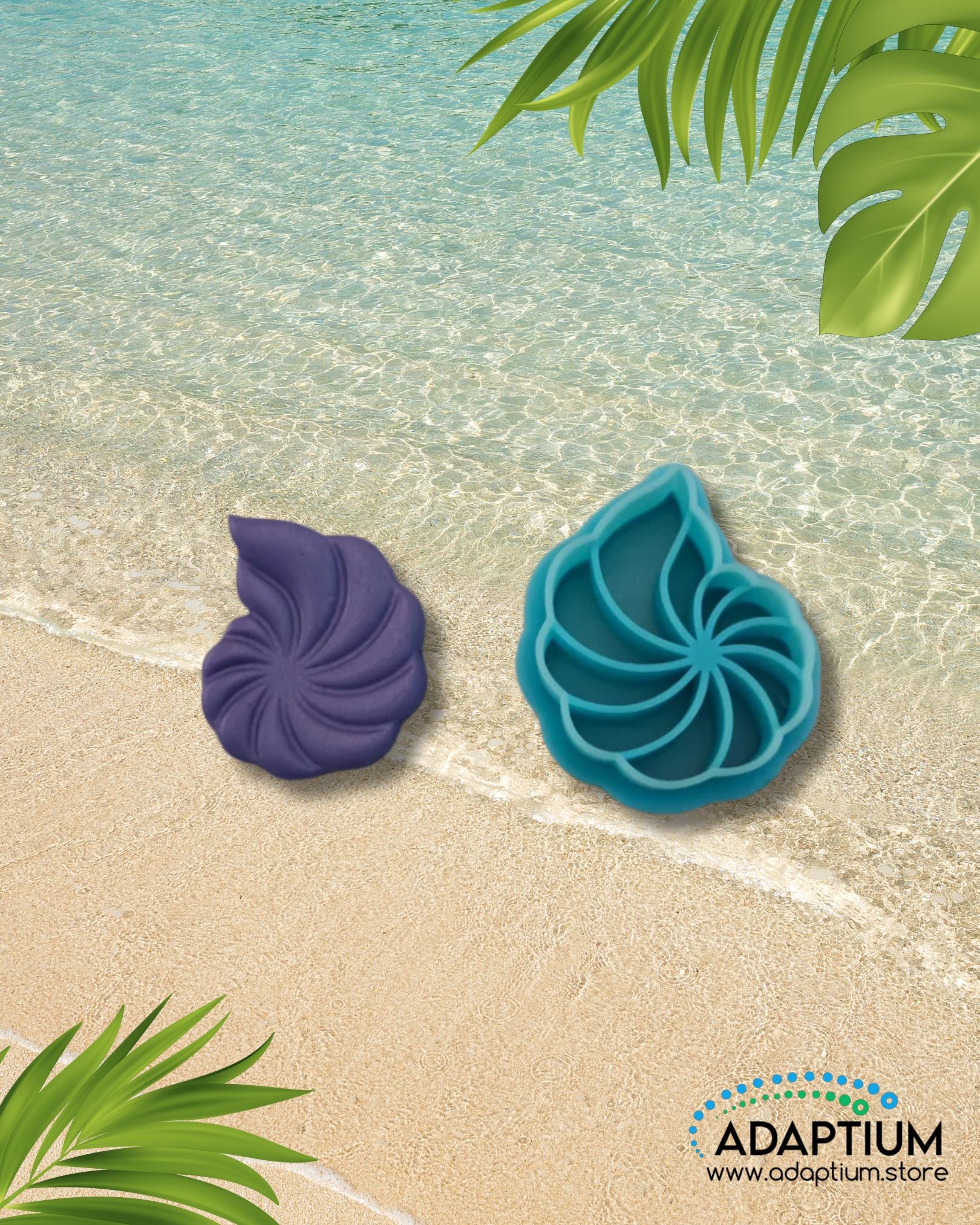 Blue swirl seashell polymer clay cutter with matching purple clay piece placed on sandy beach background with ocean water and tropical leaves.
