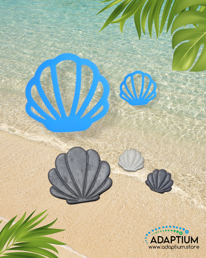 Clam shell shaped polymer clay cutter with clay sample placed on sandy beach background with ocean water and tropical leaves.