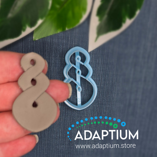 Hand holding a raw piece of polymer clay cut out from the pale blue resin pikorua twist cutter