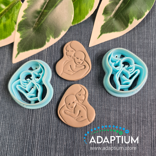 Mama & baby embossed Sky Blue Resin Cutters.  Left & right with grey examples of what it looks like in raw polymer clay 